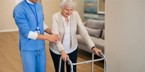 Person using a walker with assistance.